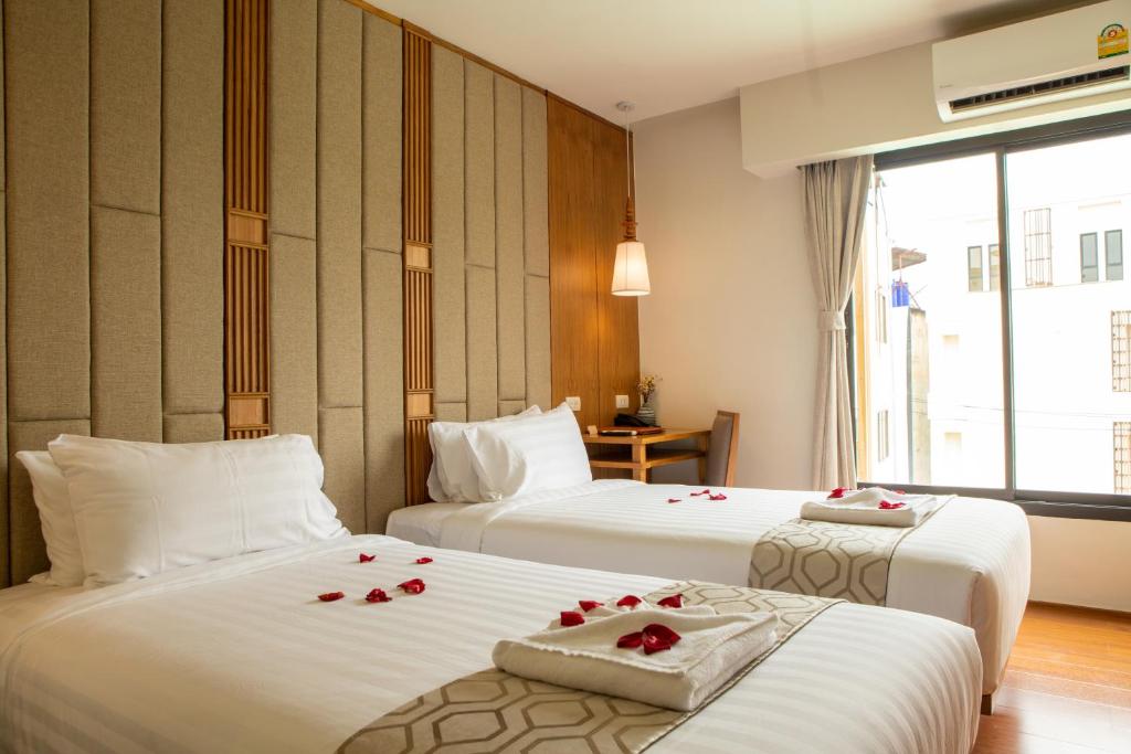 清邁的住宿－Lanna Thaphae Hotel，酒店客房设有两张带玫瑰花的床。
