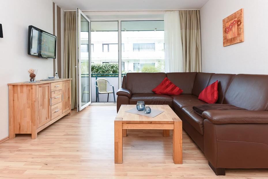 a living room with a brown couch and a coffee table at Klippersteven in Wangerooge