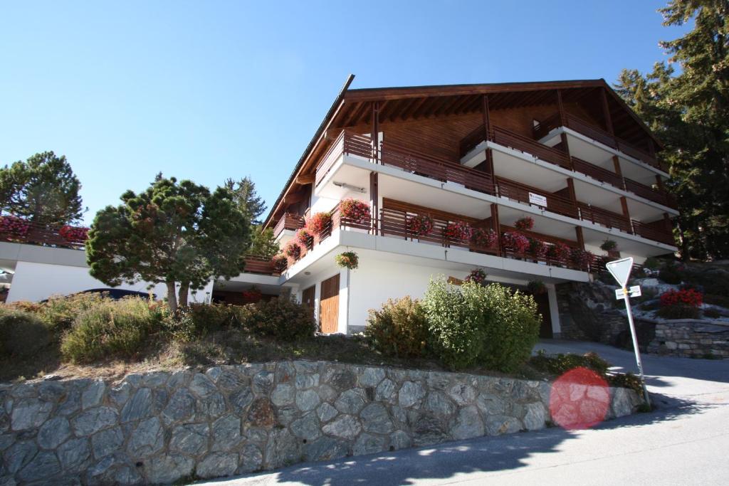 a large white building with a brown roof at Residence Tsaumiau in Crans-Montana