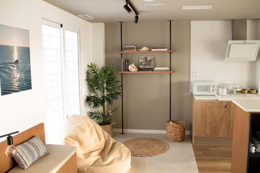 a living room with a kitchen with a sink at Sosiego Hostal de Mar in Puerto de Mazarrón