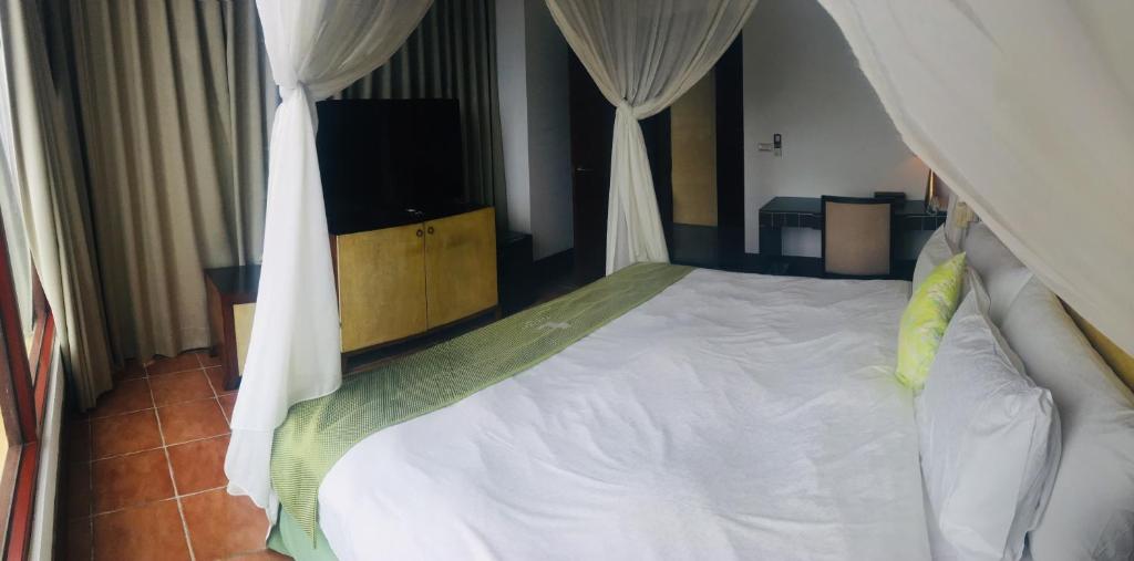 a bedroom with a white bed and a television at The Loft Seaside Suites in Jinshan