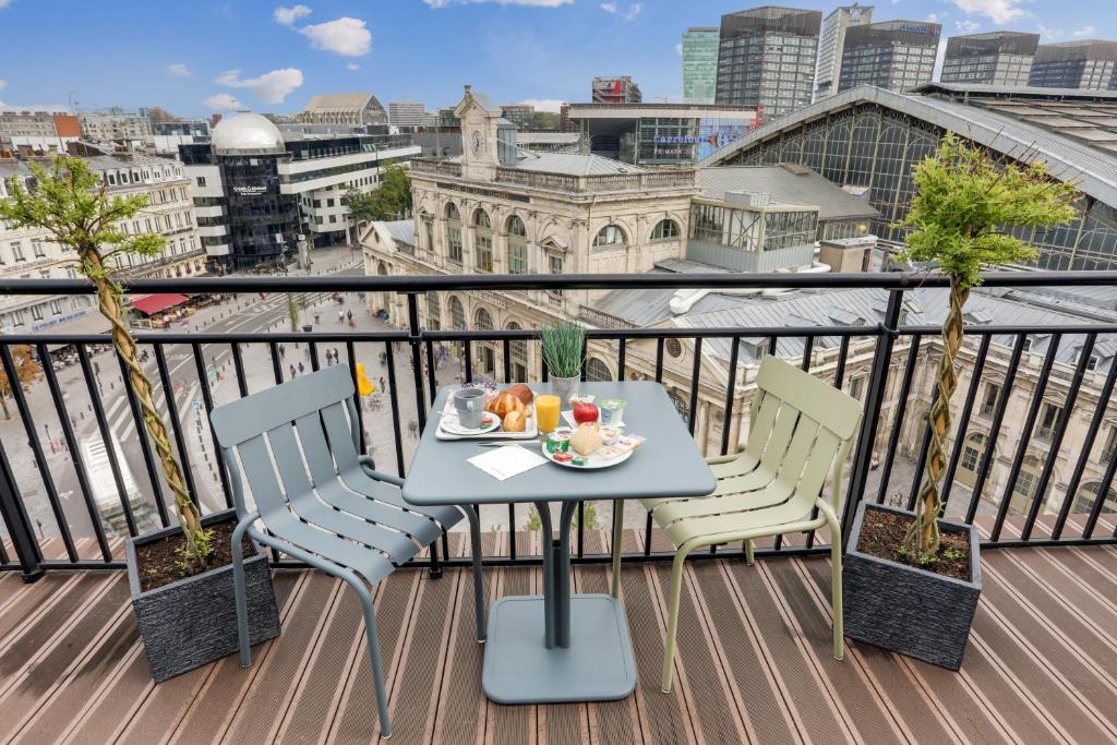 uma mesa com um prato de comida numa varanda em Hotel Chagnot em Lille