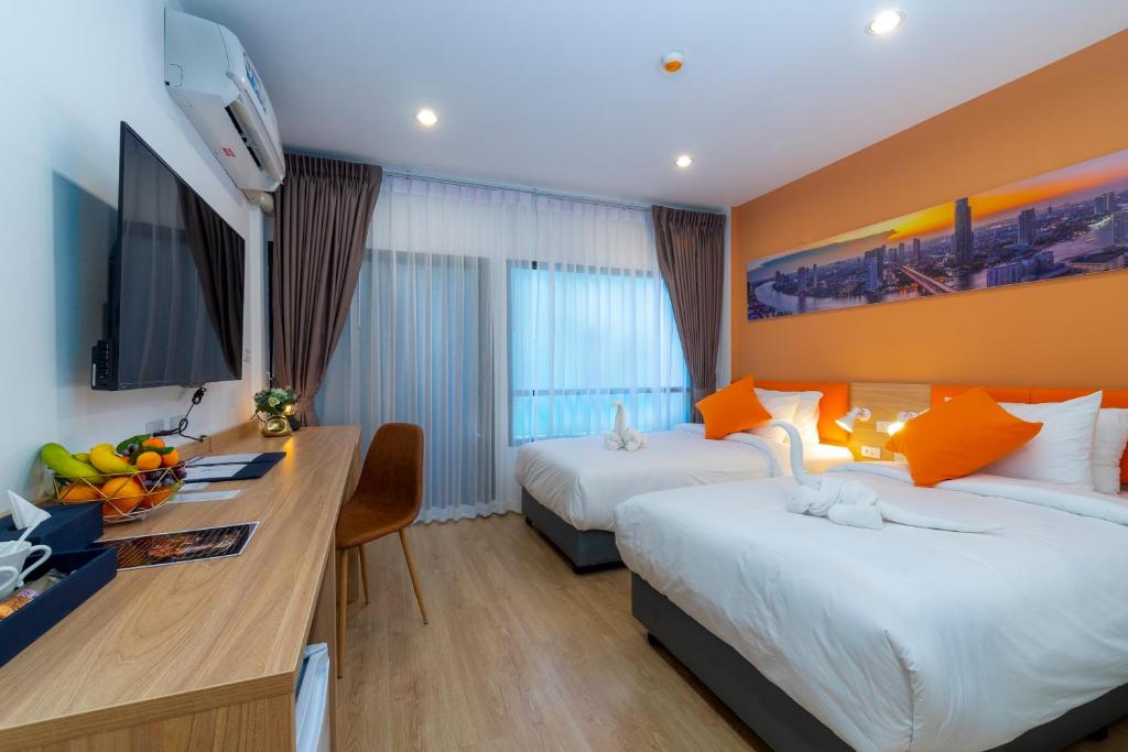 a hotel room with two beds and a desk at 7 Days Premium Hotel Don Meaung Airport in Ban Don Muang