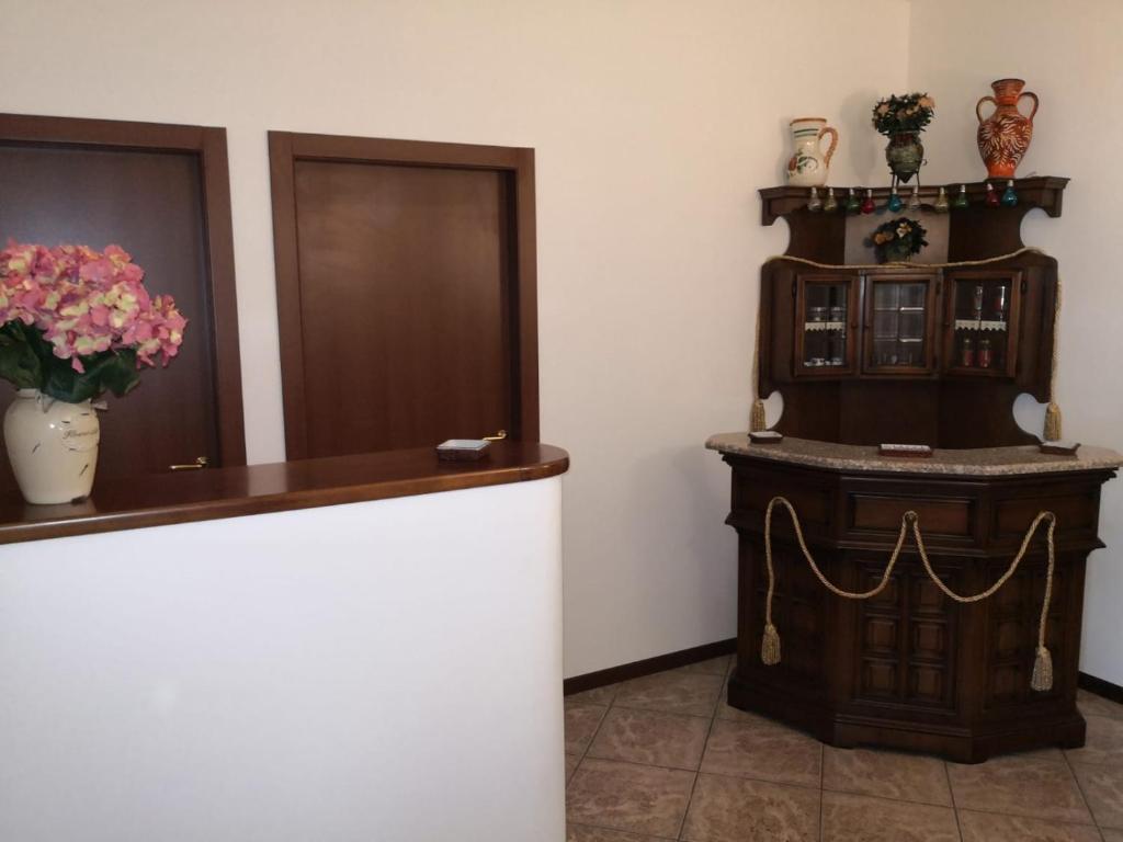 a room with a counter with a vase of flowers at LUX RHO FIERA in Lainate