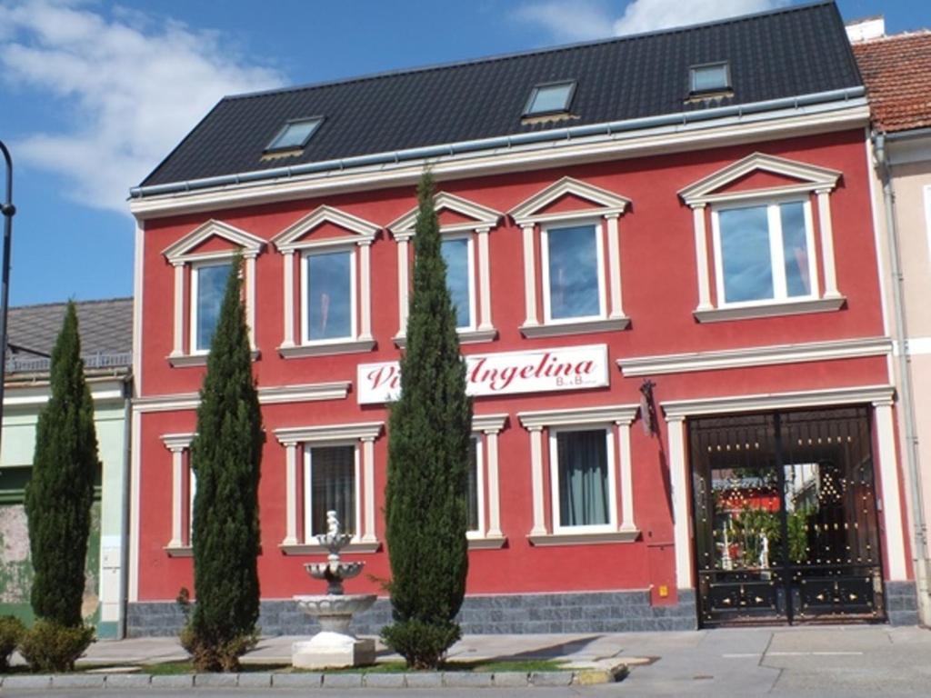 un bâtiment rouge avec une pancarte sur celui-ci dans l'établissement Villa-Angelina, à Langenzersdorf