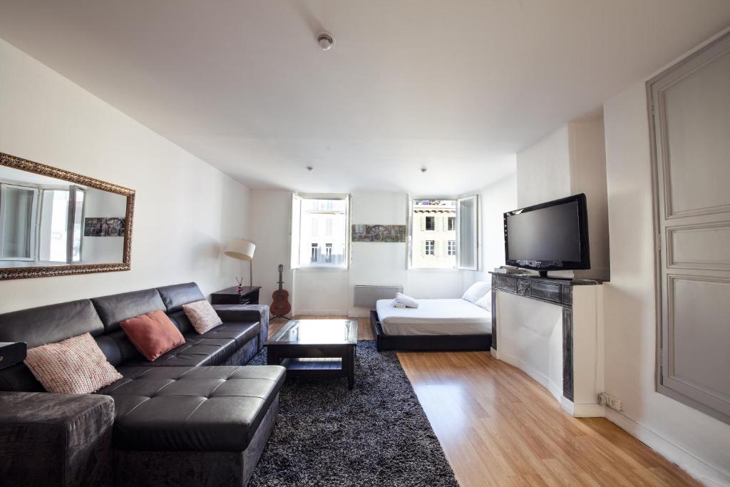 un salon avec un canapé et une télévision dans l'établissement Studio, à Marseille