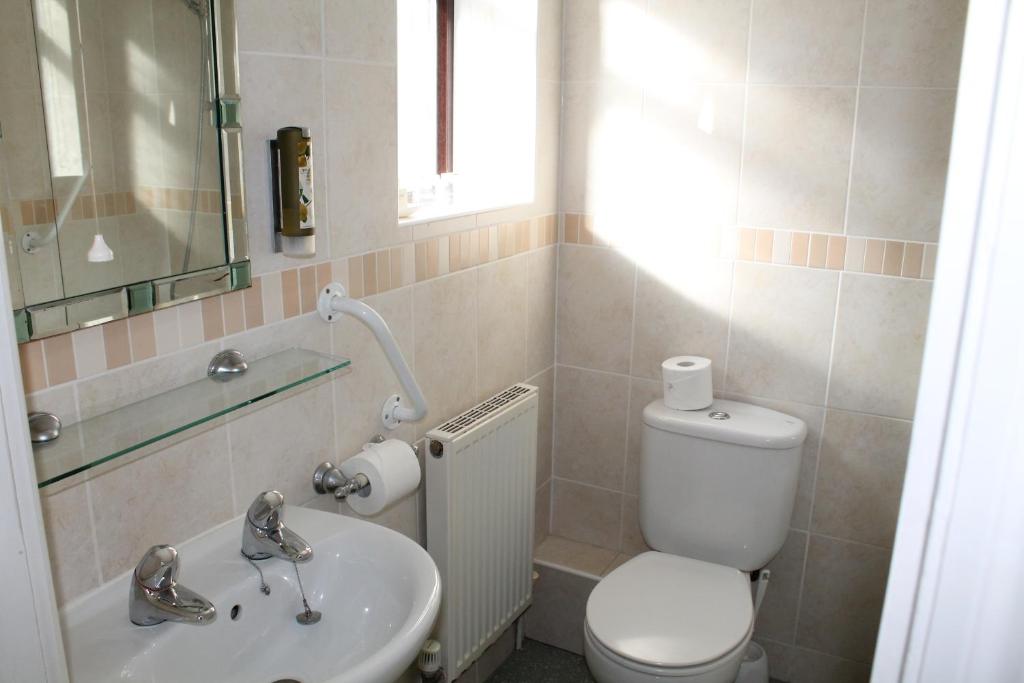 a bathroom with a toilet and a sink at The Pines Hotel in Swanage