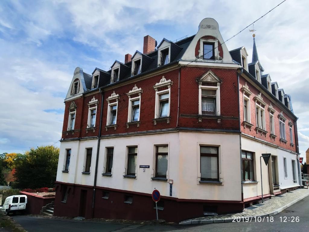 un bâtiment rouge et blanc avec une tour d'horloge dans l'établissement Privatzimmer, à Siebenlehn