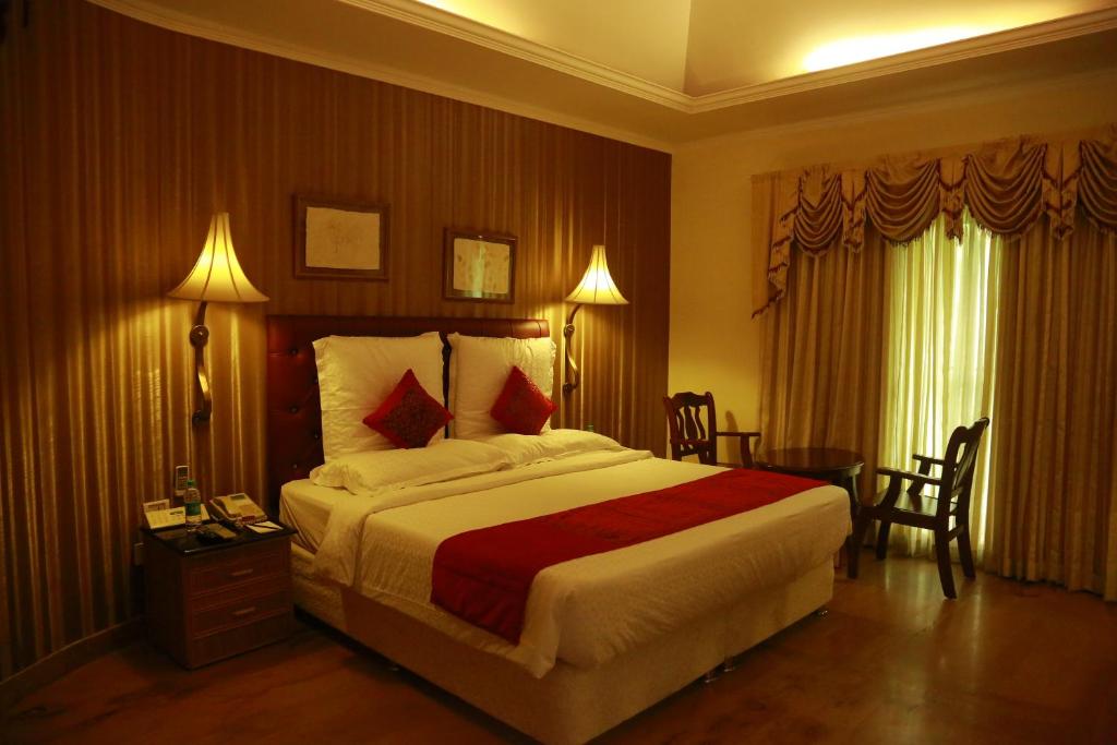 Postel nebo postele na pokoji v ubytování SAJ Earth Resort & Convention Center , Kochi