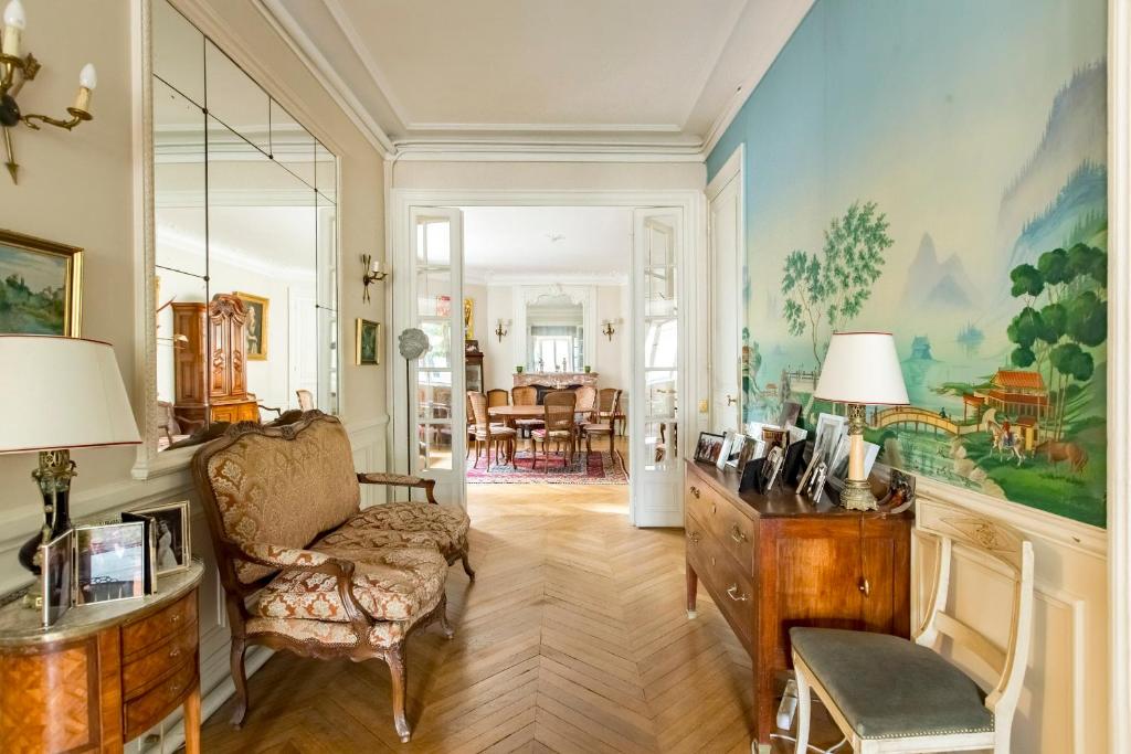 a living room with a chair and a dresser in a room at Veeve - Enchanting Murals by Trocadero Gardens in Paris