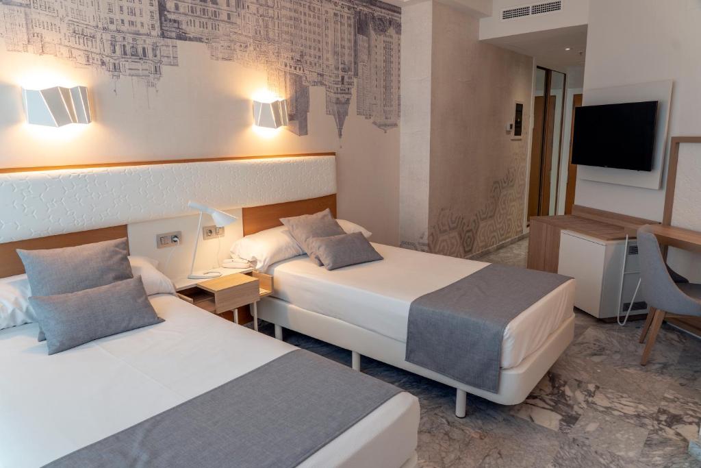 Кровать или кровати в номере Hotel Madeira Centro