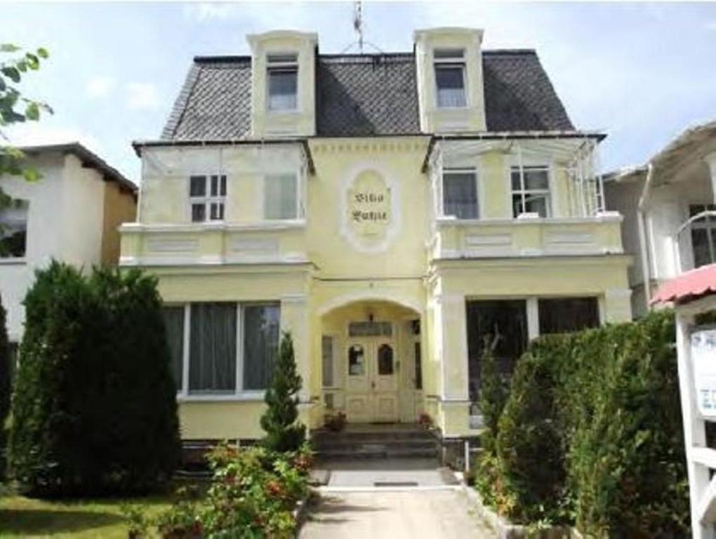 une maison blanche avec un panneau à l'avant dans l'établissement Ferienwohnung Fritz, à Zinnowitz