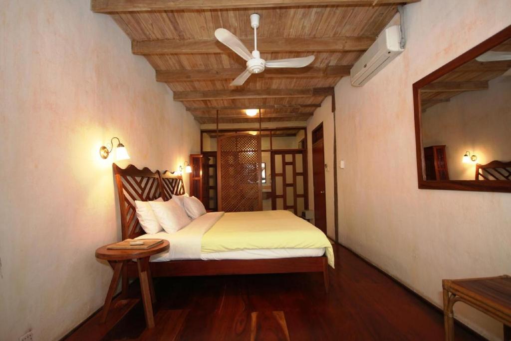 a bedroom with a bed with a ceiling fan at Sala Prabang Hotel in Luang Prabang