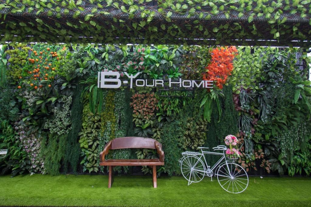 una panchina e una bicicletta davanti a un muro di B-your home Hotel Donmueang Airport Bangkok -SHA Certified SHA Plus a Bangkok