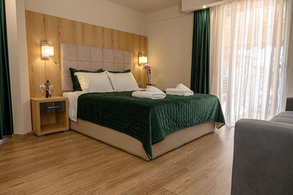 a bedroom with a large bed with a green bedspread at Oxygen in Olympiaki Akti