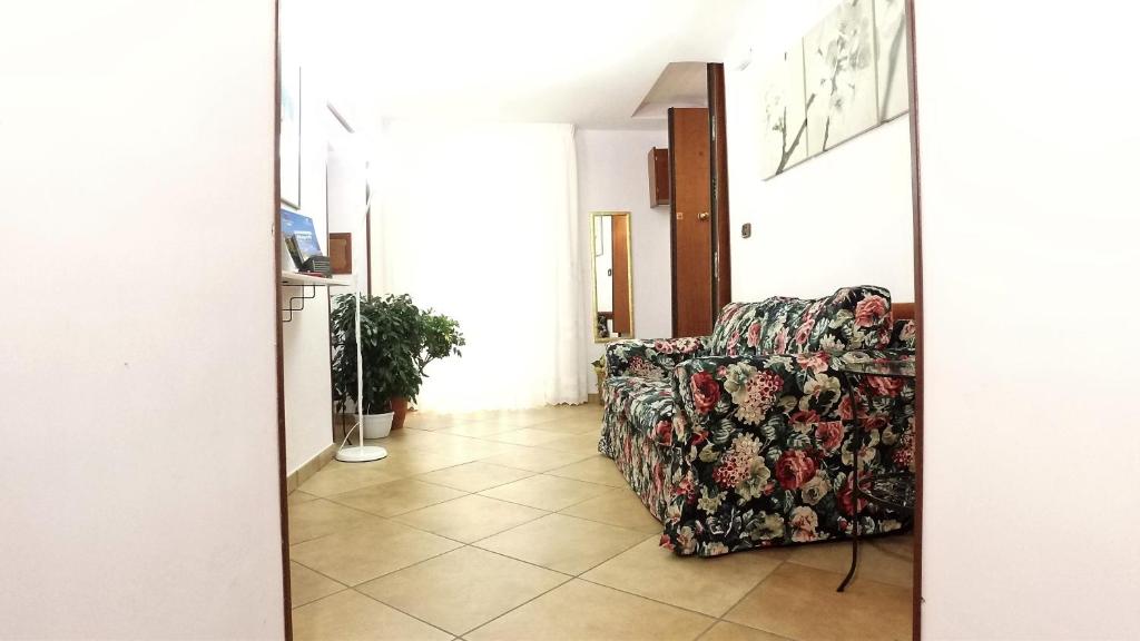 uma sala de estar com uma cadeira floral num corredor em B&B Ersilia em Nápoles