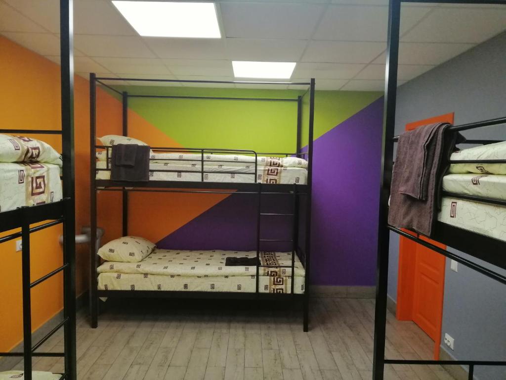 a room with three bunk beds with colorful walls at Hostel Meridian in Kyiv