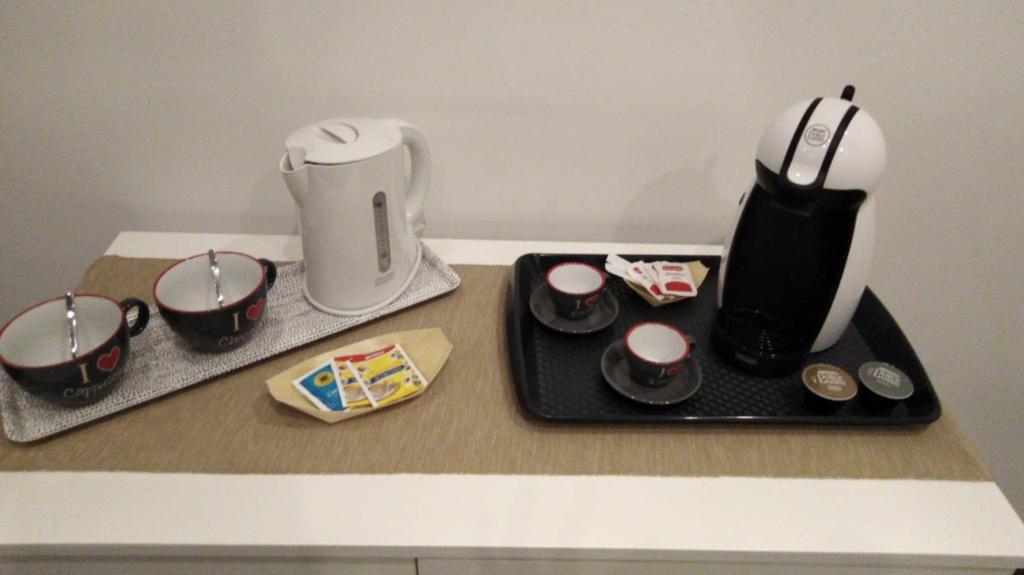 eine Theke mit Kaffeemaschine und Tassen auf einem Tablett in der Unterkunft Maison Arena in Neapel