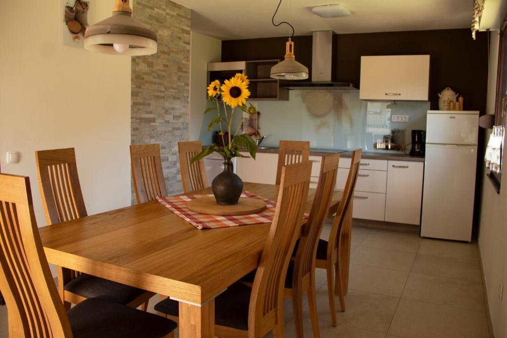a kitchen with a wooden table with a vase with a sunflower at Apartments Bobi in Tolmin