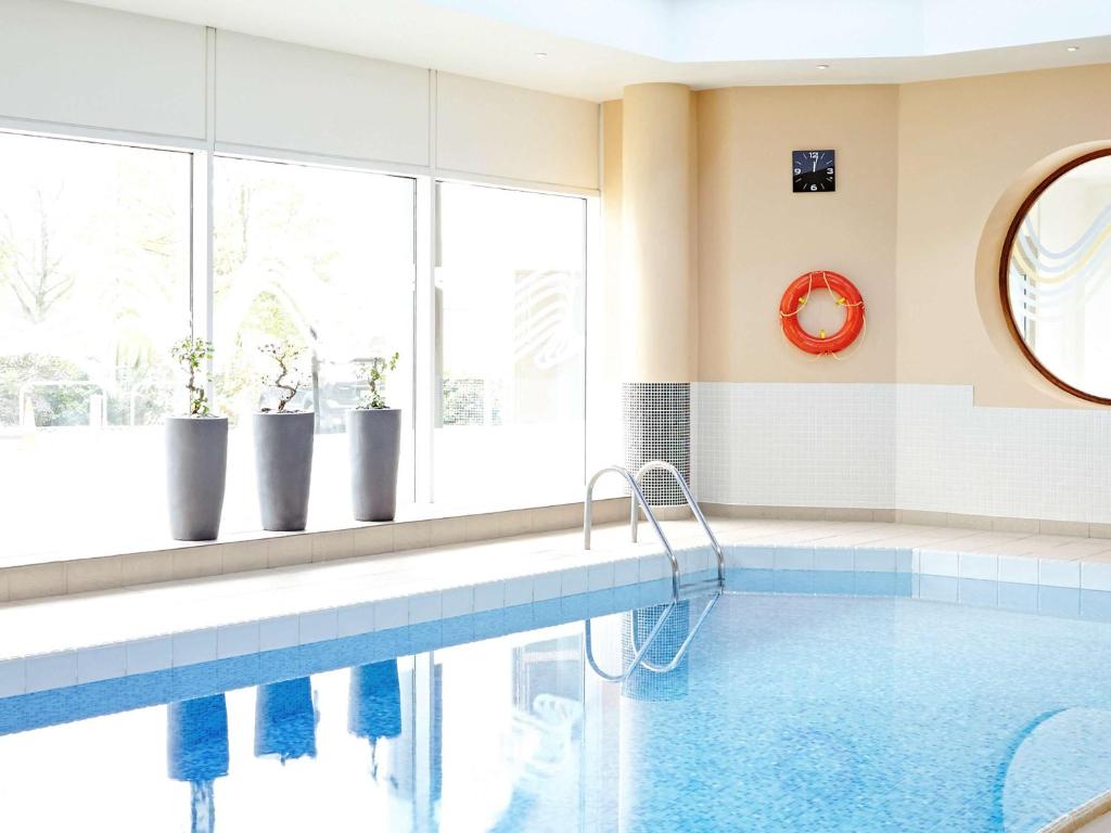 a swimming pool in a room with a large window at Novotel Sheffield Centre in Sheffield