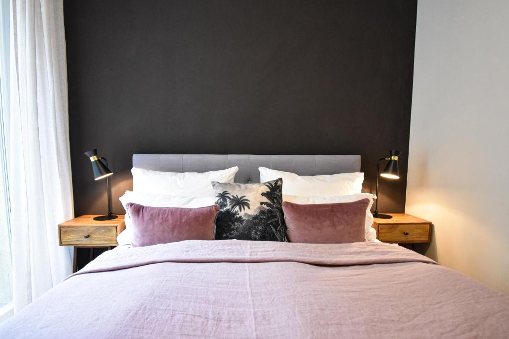 ライプツィヒにある100 qm Luxus Industrial Apartmentのベッドルーム1室(ピンクのシーツと枕が備わる大型ベッド1台付)