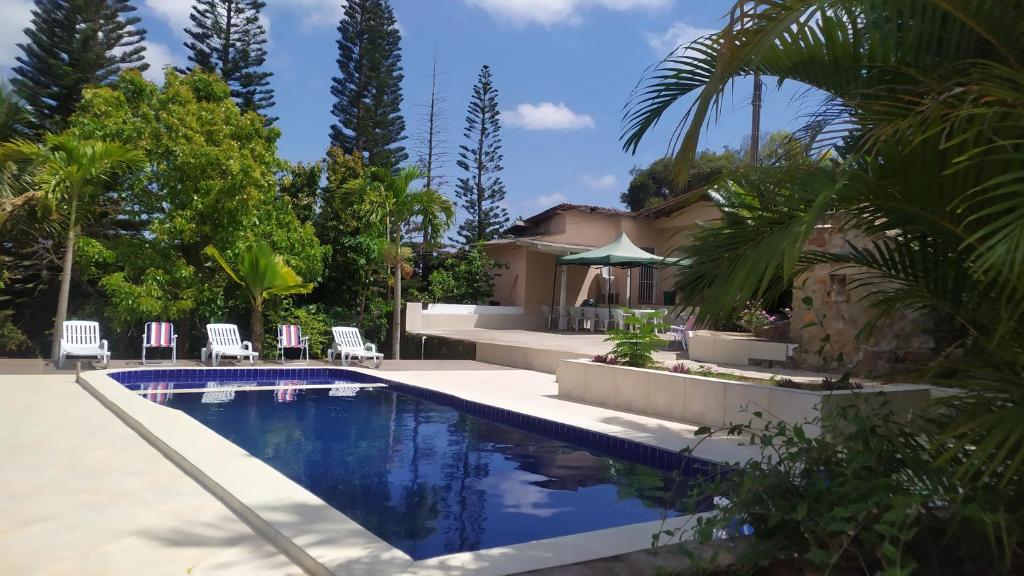 a house with a swimming pool and palm trees at CHÁCARA SANTA TERESA in Triunfo