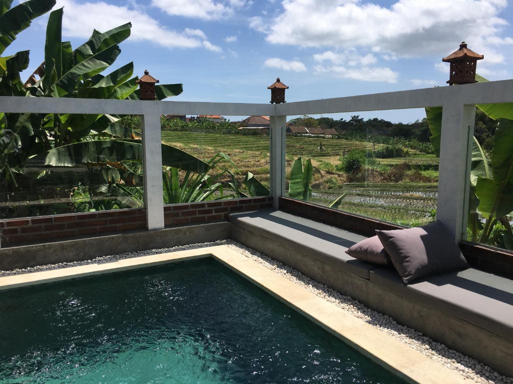 ein Tauchbecken im Garten mit einer Pergola in der Unterkunft Alunan Villa - Canggu in Canggu