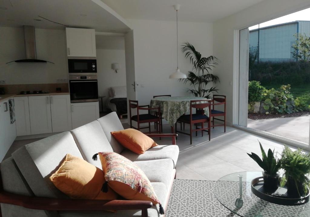 a living room with a couch and a table at Esprit Cottage "4 étoiles" sables d'Or les pins in Plurien