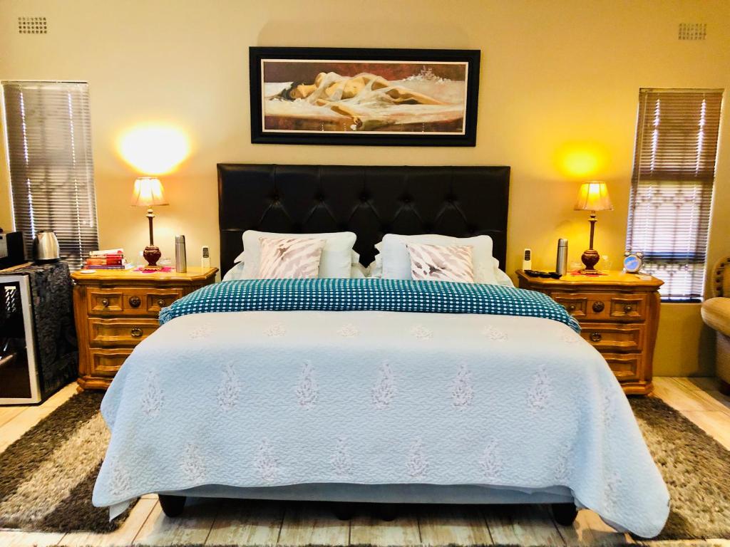 a bedroom with a large bed and two night stands at Rooibos Retreat in Richards Bay