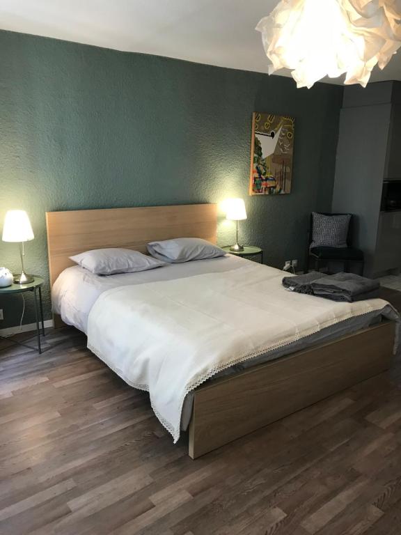 um quarto com uma cama grande com lençóis brancos em Studio SIEVA em Lausana