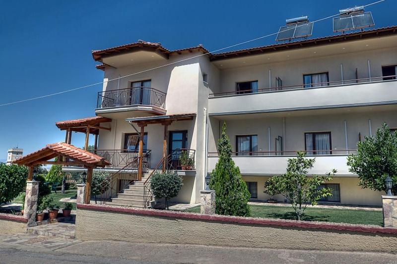 um grande edifício branco com escadas e varandas em Guesthouse Evi Maria em Ángistron