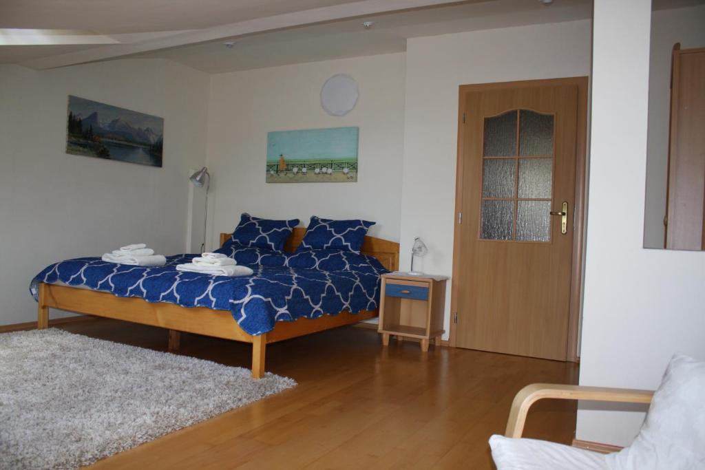 a bedroom with a bed with a blue comforter at RENMIR in Poprad