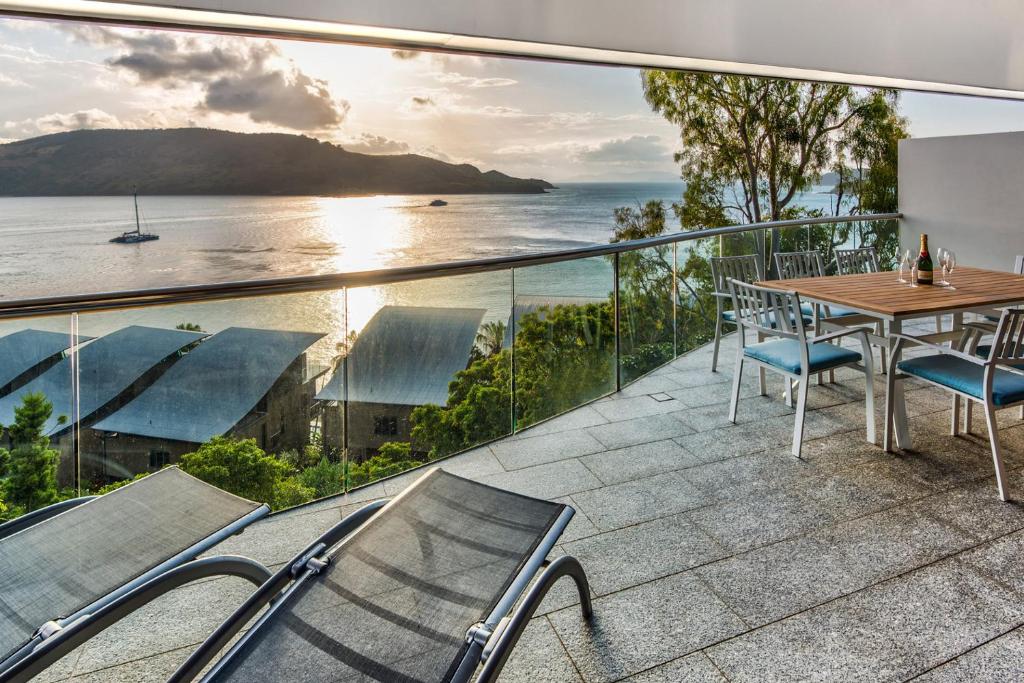 uma varanda com mesa e cadeiras e vista para o oceano em Waves 5 Luxury 3 Bedroom Breathtaking Ocean Views Central Location em Hamilton Island