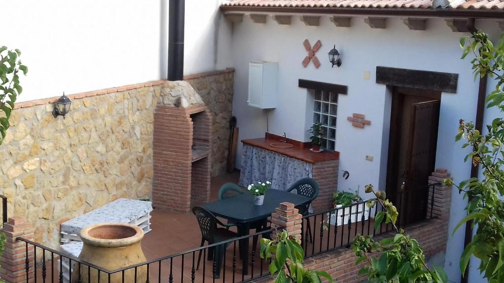 un balcón de una casa con mesa y sillas en Casa Rural Las Nogueras, en Caserío Arroyofrío