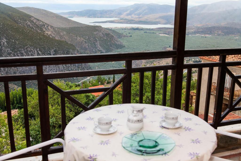 una mesa con tazas y platillos en el balcón en Apollon Stone Villa in Delphi with Stunning View!, en Delfos