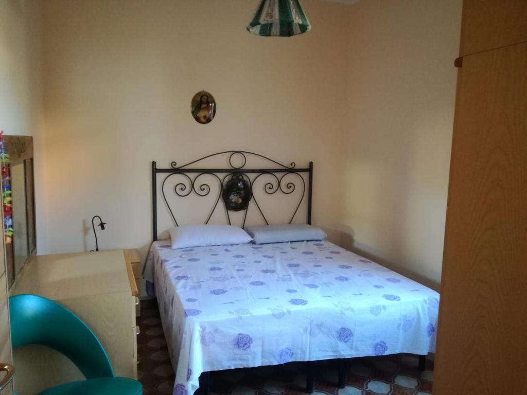 a bedroom with a large bed with a blue comforter at Calabrian Home in Casa Roccani