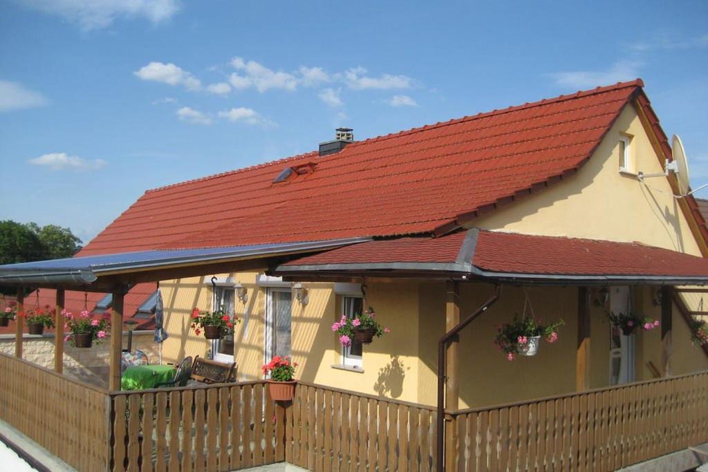 una casa con techo rojo y valla en Drachenstein, en Wutha-Farnroda