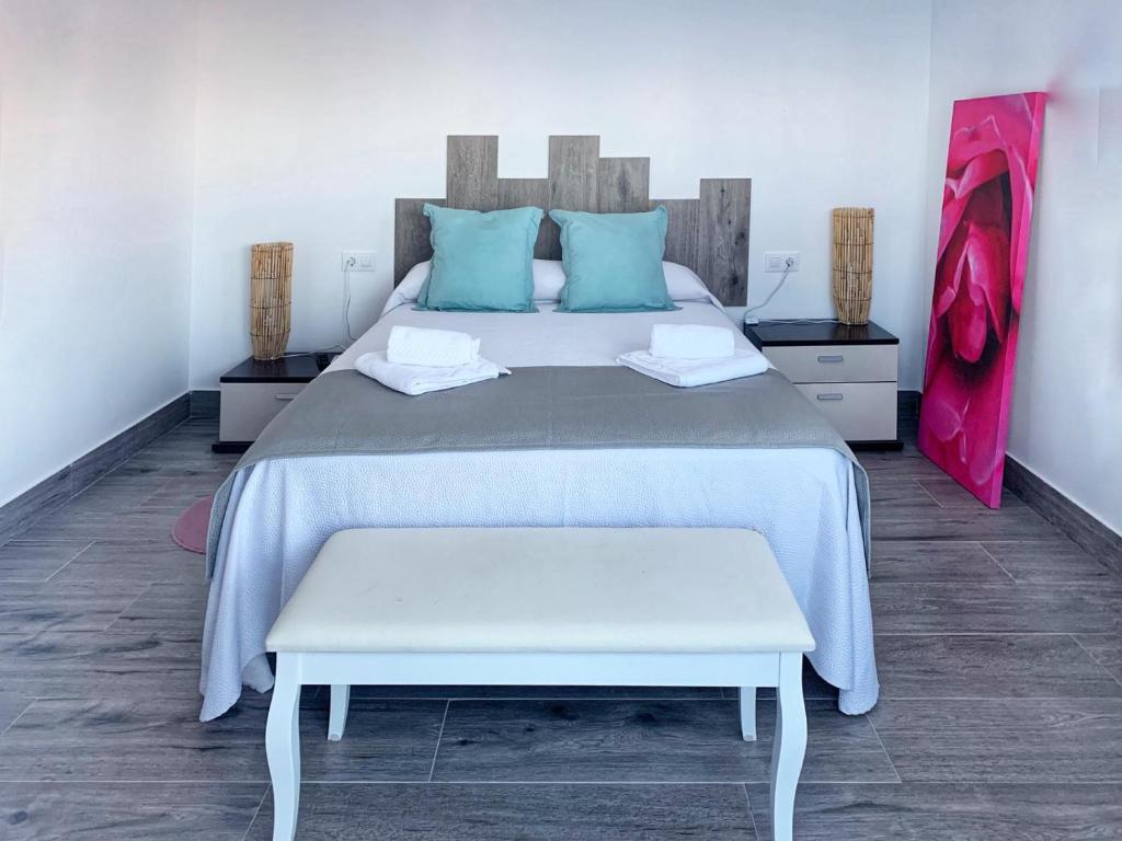 a bedroom with a large bed with blue pillows at Alojamientos 4nudos in San José