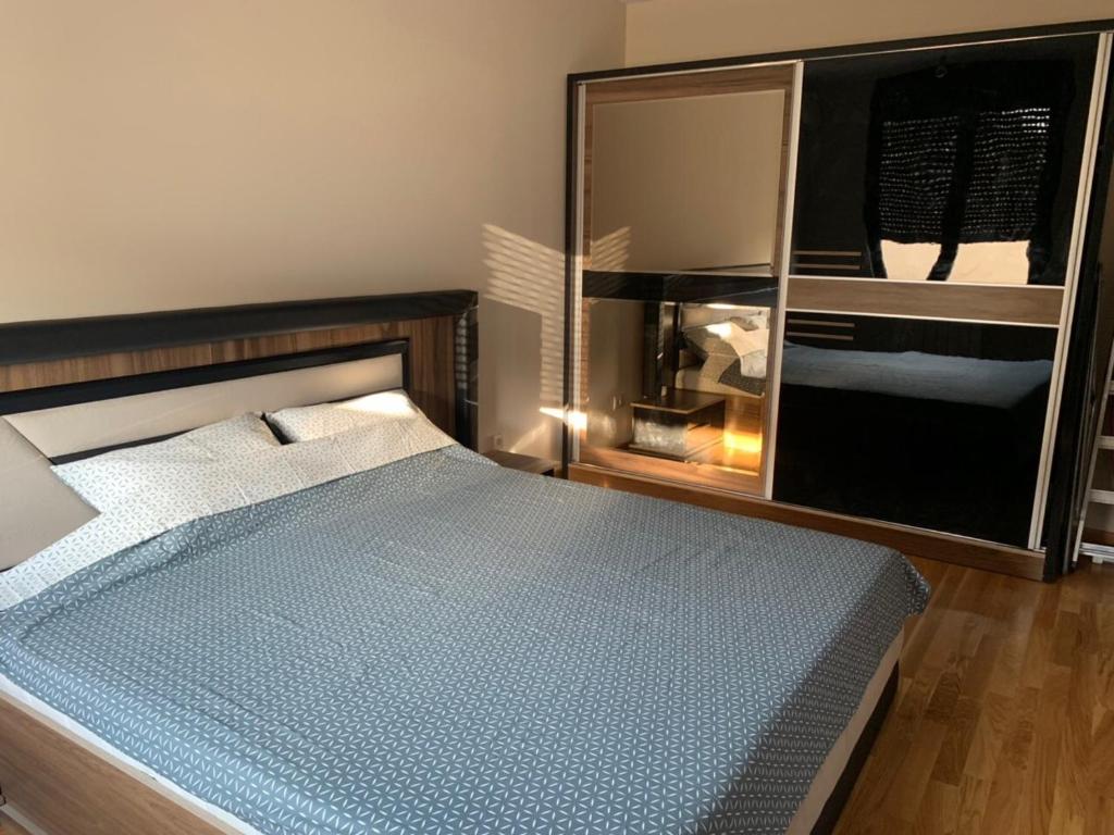 ein Schlafzimmer mit einem Bett und einem großen Spiegel in der Unterkunft BELLA APARTMENT in Belgrad
