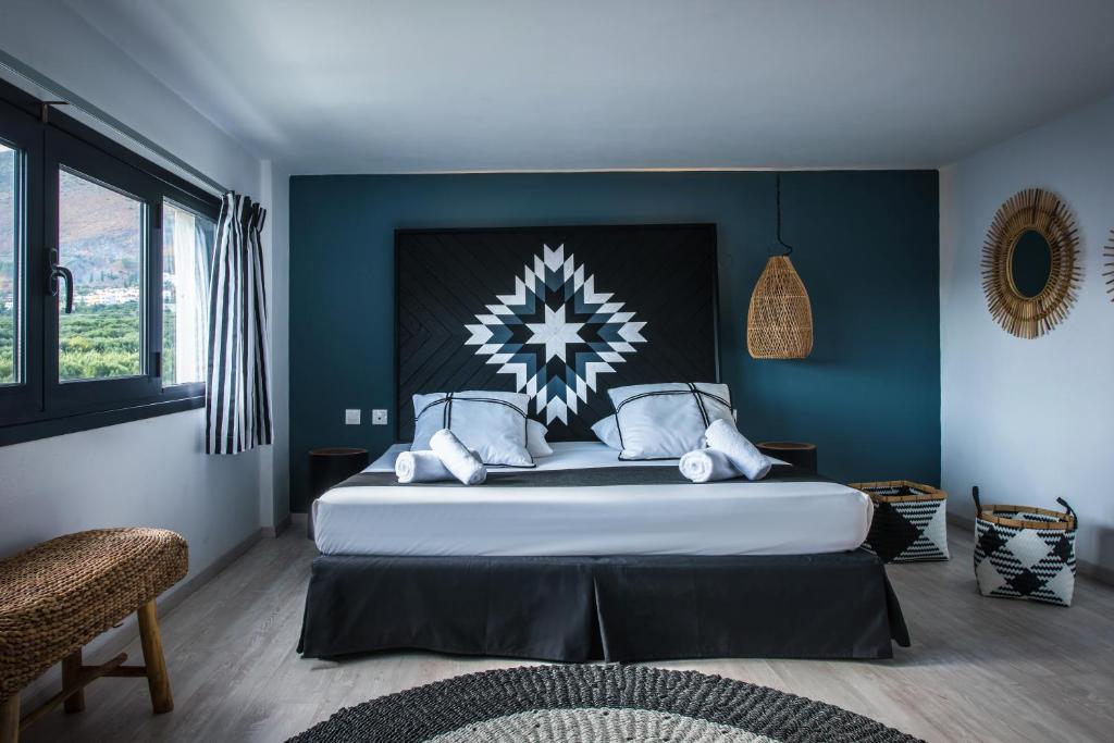 een slaapkamer met een groot bed met blauwe muren bij Indigo Inn in Chersonissos