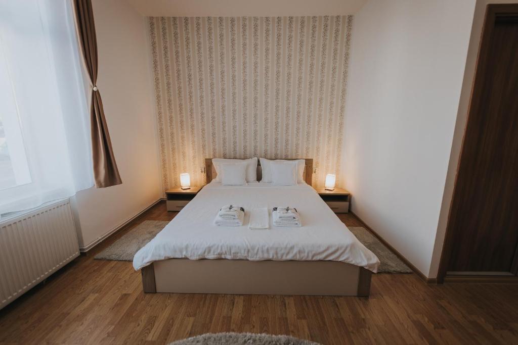 1 dormitorio con 1 cama con 2 toallas en Gavri's Classic Apartment, en Sibiu