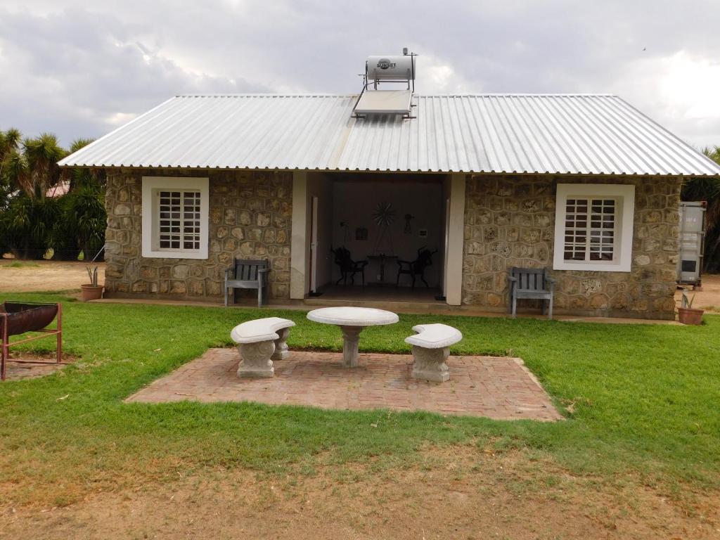 a stone house with a picnic table in front of it at Meteorite Rest Camp in Groutfontein