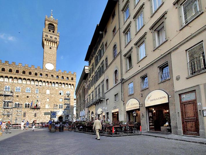 uma rua da cidade com uma torre de relógio ao fundo em Piccolo Signoria Apartment em Florença