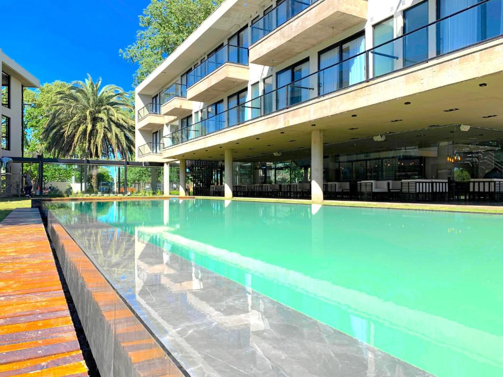 uma piscina em frente a um edifício em La Urumpta Hotel by AKEN Mind em Río Cuarto