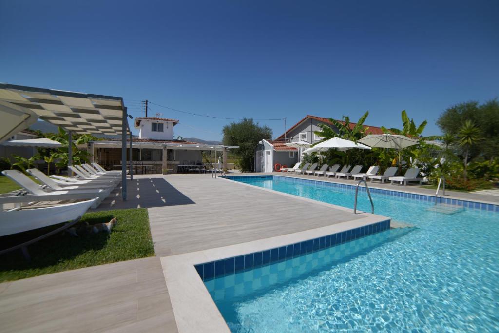 a swimming pool with lounge chairs and a resort at Mirsini Studios & Apartments in Laganas