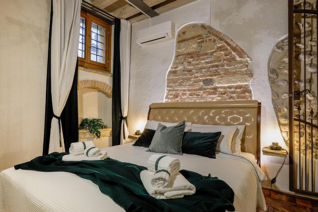 a bedroom with a bed with towels on it at Dimora Scaligera Luxury Apartment in Verona