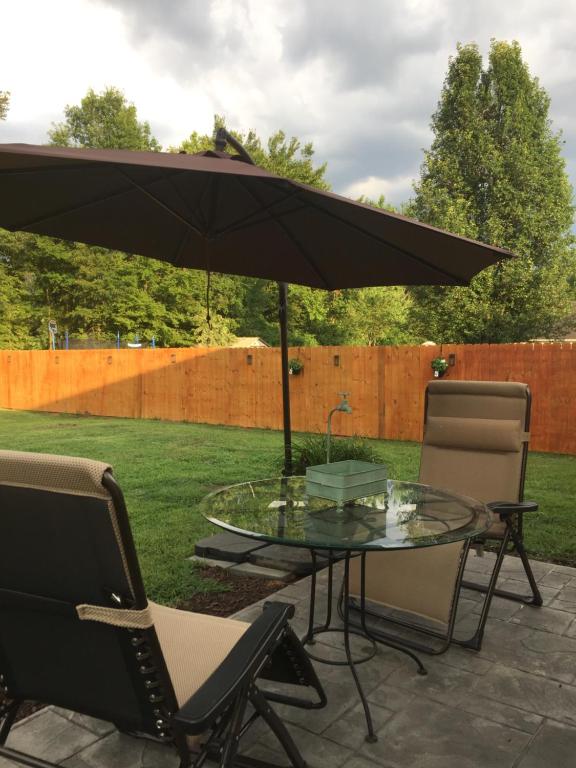 einen Tisch und Stühle mit Sonnenschirm auf einer Terrasse in der Unterkunft la casa de Carmen in Charlotte