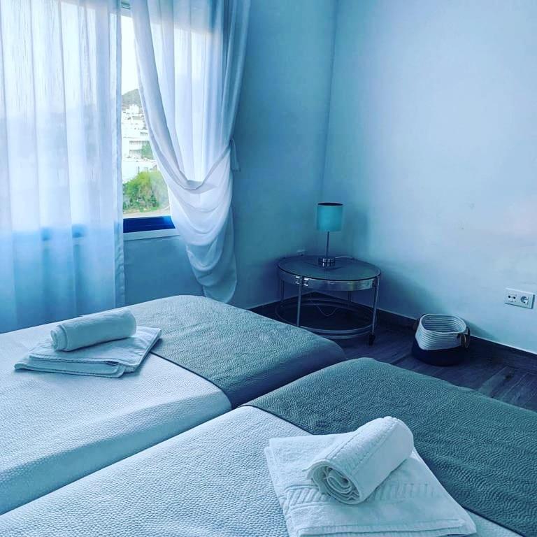 a bedroom with two beds and a table with a window at Alojamientos 4nudos in San José