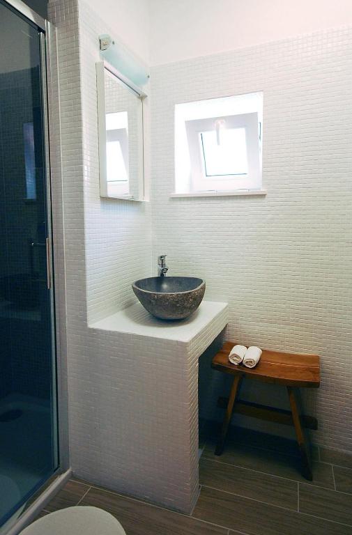 łazienka z kamienną umywalką i oknem w obiekcie Boutique Hotel Placa w Krku