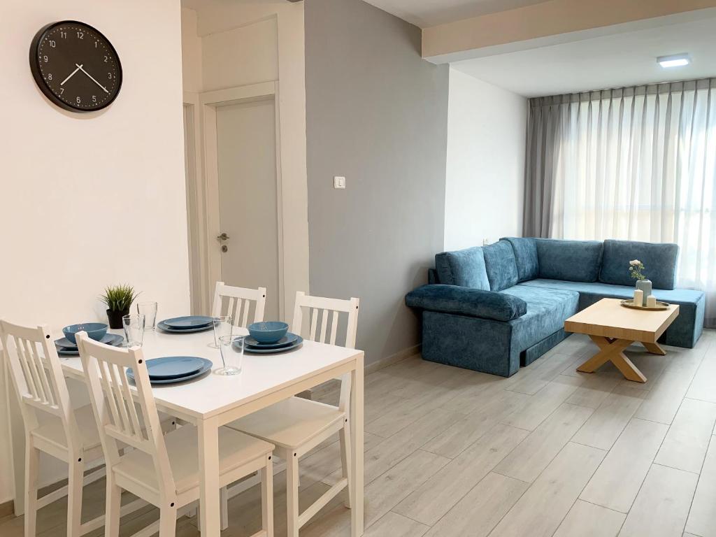 sala de estar con mesa y sofá azul en Mor's Place, en Beer Sheva